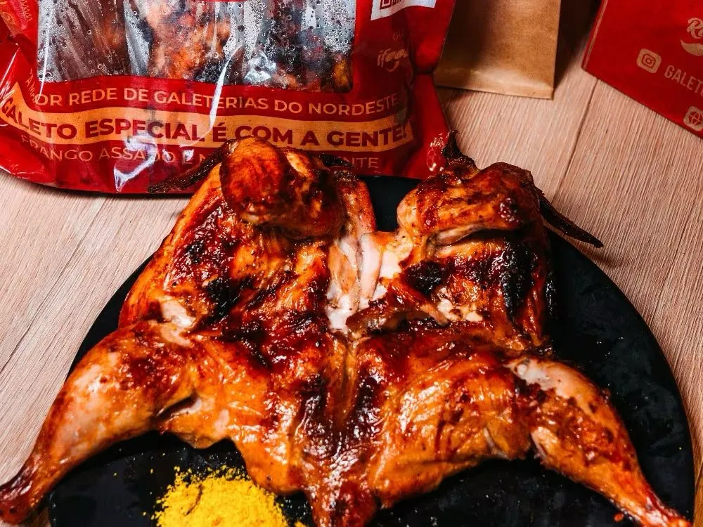 Galeto aberto no prato, com a pele dourada e tostada pela brasa