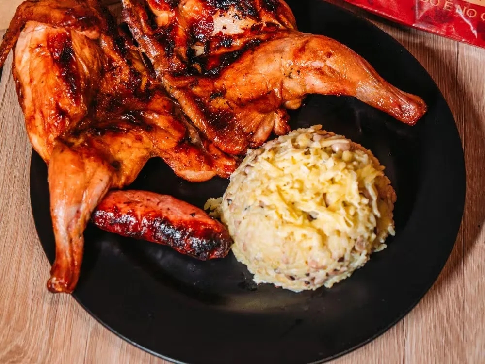 Galeto assado no prato com baião de dois cremoso e linguiça toscana